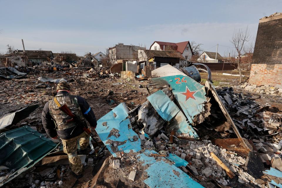 A member of the Ukrainian Territorial Defence Forces inspects remains of a Russian Sukhoi Su-34 fighting aircraft among residential area, as Russia's attack on Ukraine continues, in Chernihiv, Ukraine April 6, 2022. REUTERS/Serhii Nuzhnenko