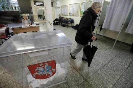 A woman walks to a voting booth during general election in Vilnius, Lithuania, October 9, 2016. REUTERS/Ints Kalnins