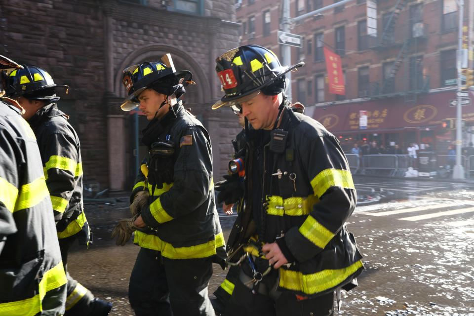 NEW YORK, NEW YORK - JANUARY 24: Firefighters walk at the scene of fire in Chinatown on January 24, 2020 in New York City. The fire, which is under investigation, severely damaged a historic building that has been home to a senior center and other nonprofits for decades and injured nearly a dozen people. Chinatown is preparing for Lunar New Year events tomorrow, which marks the start of the year of the rat. (Photo by Spencer Platt/Getty Images)