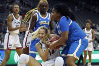 Connecticut forward Dorka Juhasz (14) and UCLA forward IImar'I Thomas (24) battle for a rebound during the first half of an NCAA college basketball game in Newark, N.J., Saturday, Dec. 11, 2021. (AP Photo/Noah K. Murray)