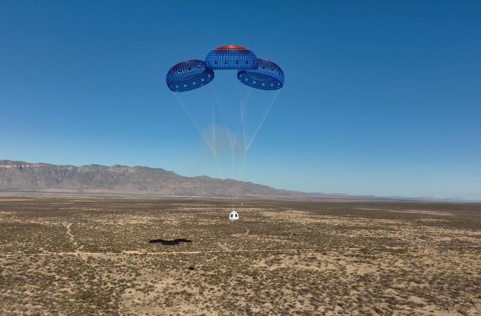 Blue Origin's fourth crewed New Shepard capsule descends to the West Texas desert beneath a trio of parachutes on March 31.