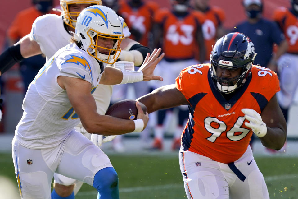 FILE - Los Angeles Chargers quarterback Justin Herbert (10) runs as Denver Broncos defensive end Shelby Harris (96) pursues during the first half of an NFL football game in Denver, in this Sunday, Nov. 1, 2020, file photo. After missing the past four games because of COVID-19, Harris will return to the Broncos lineup Sunday evening when Denver travels to Kansas City to face the Chiefs. (AP Photo/David Zalubowski, File)