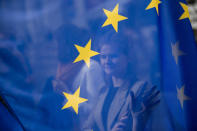 A woman touches an European Union flag during an anti Brexit protest outside the European Council headquarters in Brussels, Wednesday, Oct. 17, 2018. European Union leaders are converging on Brussels for what had been billed as a "moment of truth" Brexit summit but which now holds little promise for a breakthrough. (AP Photo/Francisco Seco)