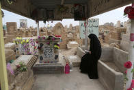 In this Wednesday, Feb. 15, 2017 photo, the sister of Iraqi Army officer, Hamza Finjan, prays at his grave in Wadi al-Salam, or "Valley of Peace" cemetery which contains the graves of security forces and militiamen killed from fighting with Islamic State group militants, in Najaf, 100 miles (160 kilometers) south of Baghdad, Iraq. Hundreds of Iraqi soldiers are estimated to have died in the fight for Mosul so far, but the Iraqi government does not release official casualty reports, a move that many Iraqis view as disrespectful of their sacrifice. (AP Photo/ Khalid Mohammed)