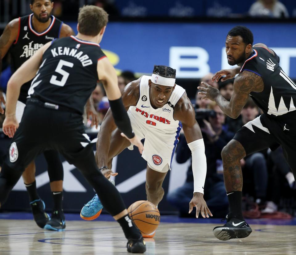 Detroit Pistons center Jalen Duren (0) chases a loose ball against Los Angeles Clippers guards Luke Kennard (5) and John Wall (11) during the first half of an NBA basketball game, Monday, Dec. 26, 2022, in Detroit. (AP Photo/Duane Burleson)