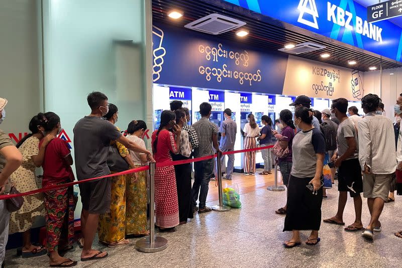 People line up in front of ATM's machines to withdraw cash, in Yangon