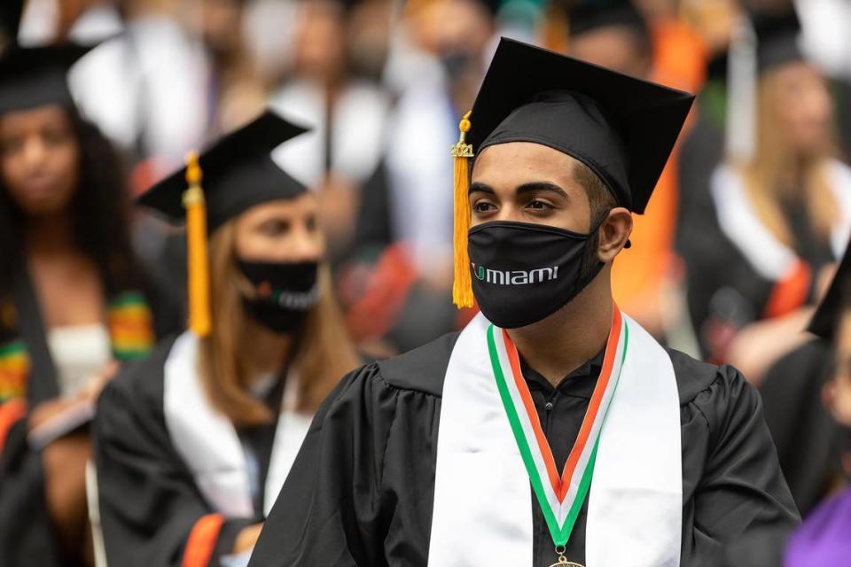 Two students sit at one of the commencement ceremonies of the University of Miami held at the Hard Rock Stadium in Miami Gardens on Friday, May 14, 2021.