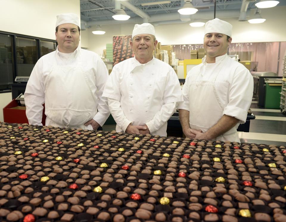 Romolo Chocolates master chocolatier Tony Stefanelli, center, runs the company with his sons Anthony Stefanelli, the company's chief chocolatier, left, and Roman Stefanelli, right, chief confectioner. Also pictured are several hundred assorted chocolates bound for Valentine's Day boxes.