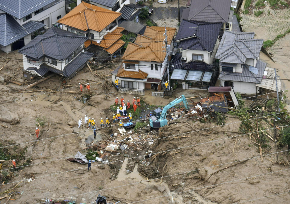 <p>Rescue workers are seen next to houses damaged by a landslide following heavy rain in Hiroshima, western Japan, in this photo taken by Kyodo July 7, 2018. (Photo: Kyodo via Reuters) </p>