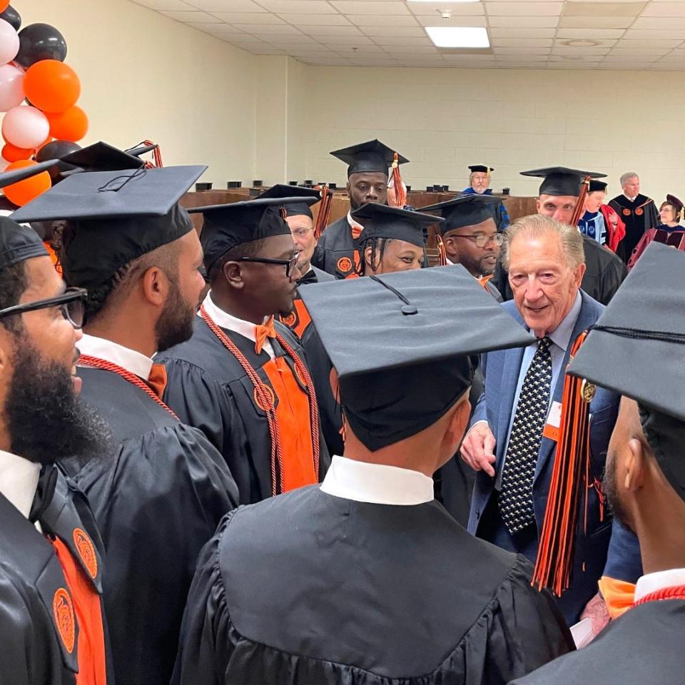 Businessman Bob Barker congratulates new Campbell University graduates at a commencement ceremony held on Thursday, Nov. 2, 2023 at Scotland Correctional Institution. The graduates are inmates at Sampson Correctional Institution and are part of the Second Chance Initiative, sponsored by the Bob Barker Foundation and operated by the Campbell and N.C. Dept. of Adult Correction.