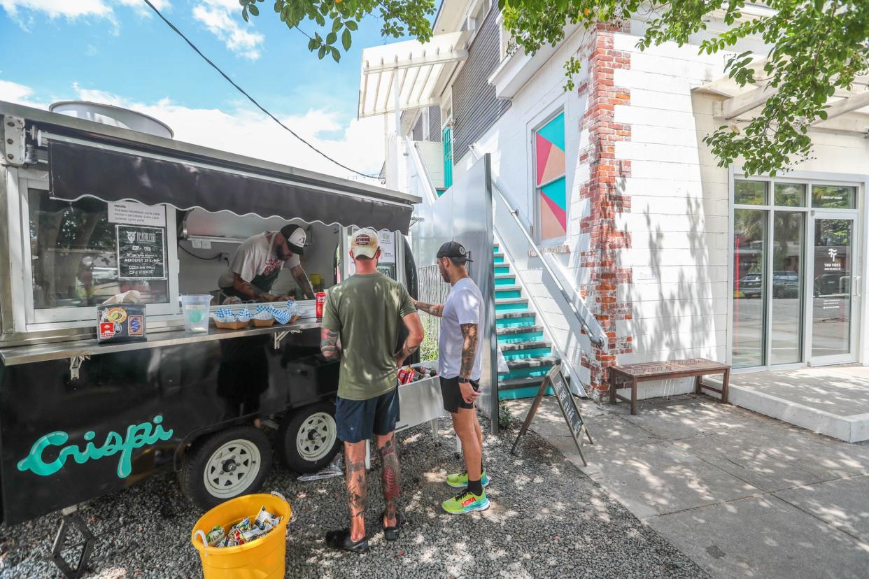 Customers place orders at the Crispi food truck at Two Tides Brewing Company on West 41st Street.