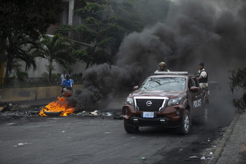 Police drive their car over a barricade set up by taxi drivers to protest fuel shortages in Port-au-Prince, Haiti, Thursday, July 14, 2022. (AP Photo/Odelyn Joseph)