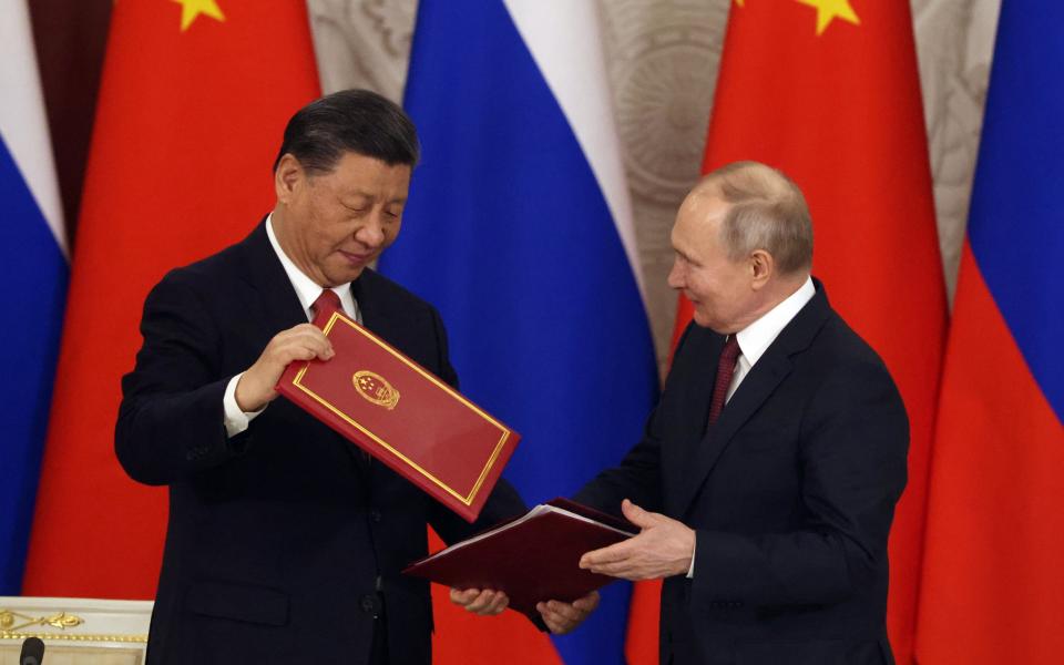 Xi and Putin compare their document folders after a signing ceremony at the Kremlin. - Getty Images Europe