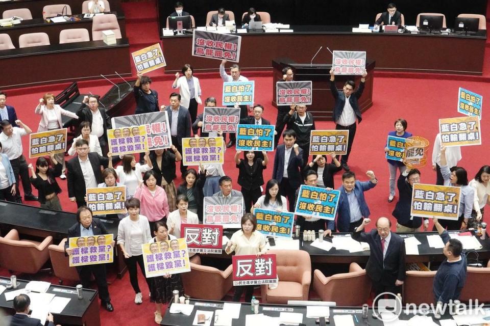 民進黨立委在立院議場舉牌反對選罷法修正草案逕付二讀，並高喊「沒收民權」等口號。   圖：張良一/攝