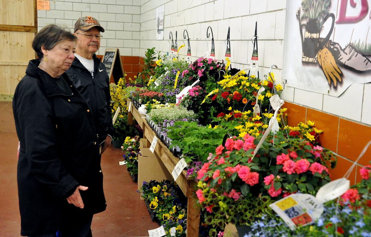 Bev and Atlee Yoder look at tables of flowering plants for sale at the 32nd annual Home and Garden Show at the Wayne County Fair Event Center.