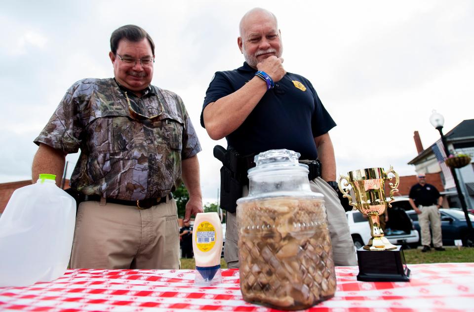 Montgomery Advertiser reporter Marty Roney and Prattville police chief Mark Thompson look at a jar of pickled pigs ahead of an eating contest on May 22, 2020.
