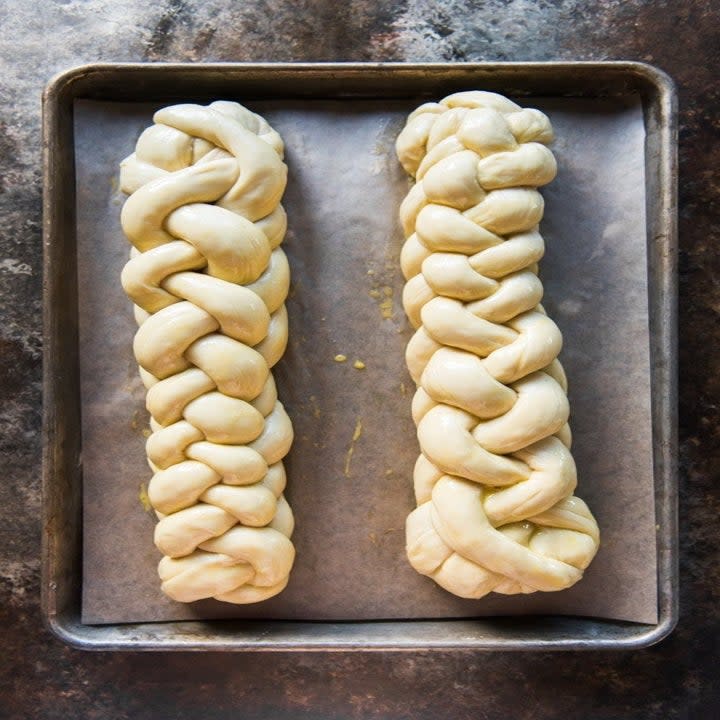 Two loaves of braided challah dough ready to be baked.