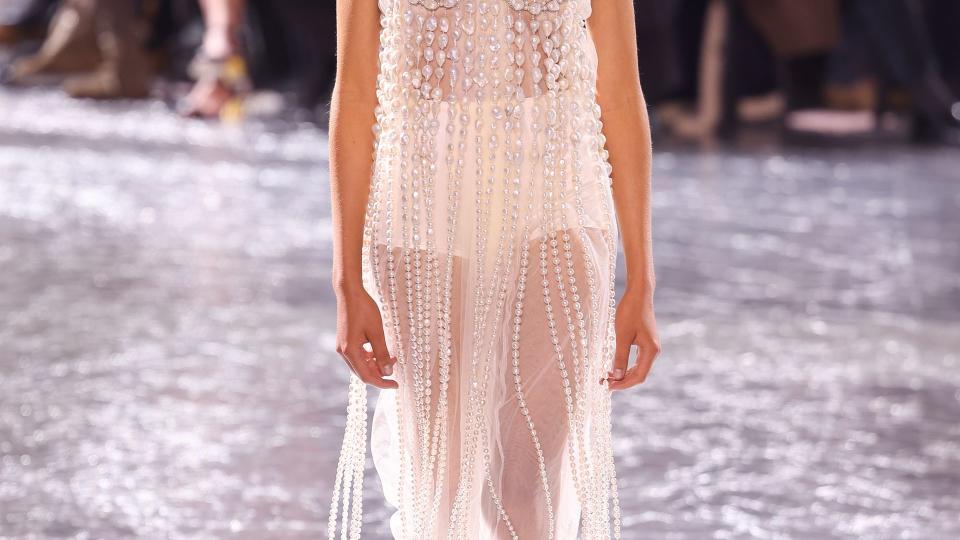 A model walks the runway during the Jean Paul Gaultier Haute Couture Spring/Summer 2024 show in a sheer white dress