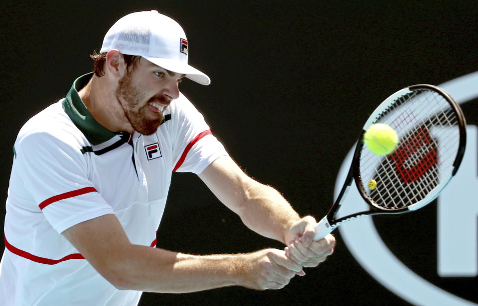 Reilly Opelka of the U.S. makes a backhand return to Italy's Fabio Fognini during their first round singles match at the Australian Open tennis championship in Melbourne, Australia, Tuesday, Jan. 21, 2020. (AP Photo/Dita Alangkara)