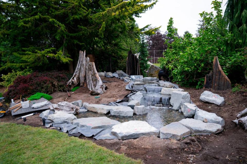 Award-winning garden designer Landen Moore, owner of Nature Perfect Landscape and Design, works on the water feature of the fairy garden at Point Defiance Park, on Thursday, May 23, 2024, in Tacoma.