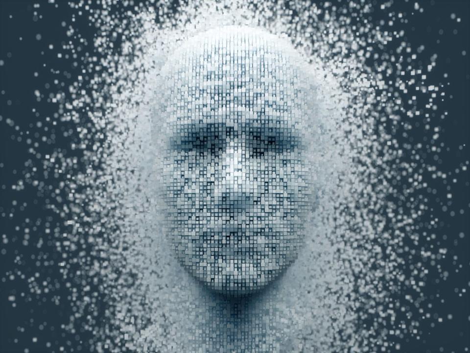 The outline of a human face emerges from a sea of ​​pixels. 