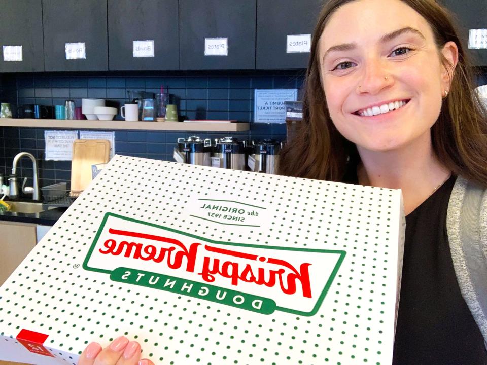 The author smiles with a box of Krispy Kreme donuts.