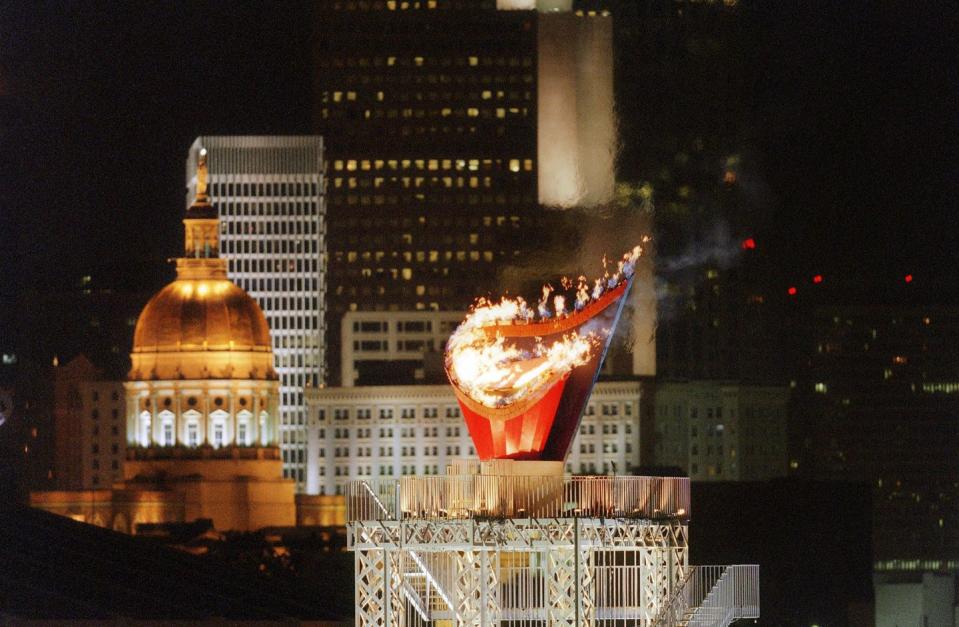 <p>The cauldron that contains the Olympic flame is as remarkable as the fiery display. Each host country is given artistic discretion to design the cauldron. Here, the Olympic flame is photographed high amidst the Atlanta skyline during the opening ceremony for the 1996 Summer Olympic Games.</p>