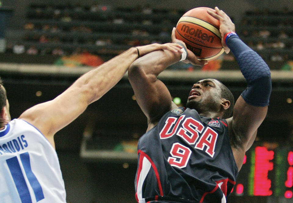 FILE - In this Sept. 1, 2006, file photo, USA's Dwyane Wade (9), right, is fouled by Greece's Dimos Dikoudis during the semifinals of the World Basketball Championships in Saitama, Japan. The 2006 world championship was perhaps the last truly wide-open international basketball event. Argentina arrived as the Olympic champion and Spain left as the world champion, the last time for a long while anyone other than the U.S. would hold either title. (AP Photo/Mark J. Terrill, File)