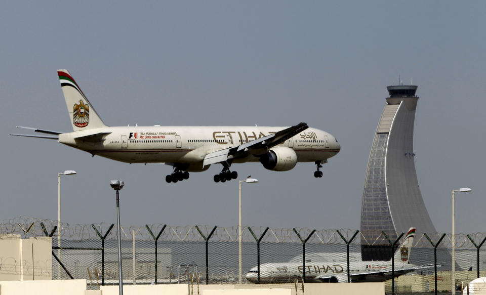 An Etihad Airways plan prepares to land at the Abu Dhabi airport, in United Arab Emirates, Sunday, May 4, 2014. Etihad Airways, a fast-growing Mideast carrier, laid out plans Sunday to offer passengers who find first-class seats a bit too tight a miniature suite featuring a closed-off bedroom, private bathroom and a dedicated butler. (AP Photo/Kamran Jebreili)