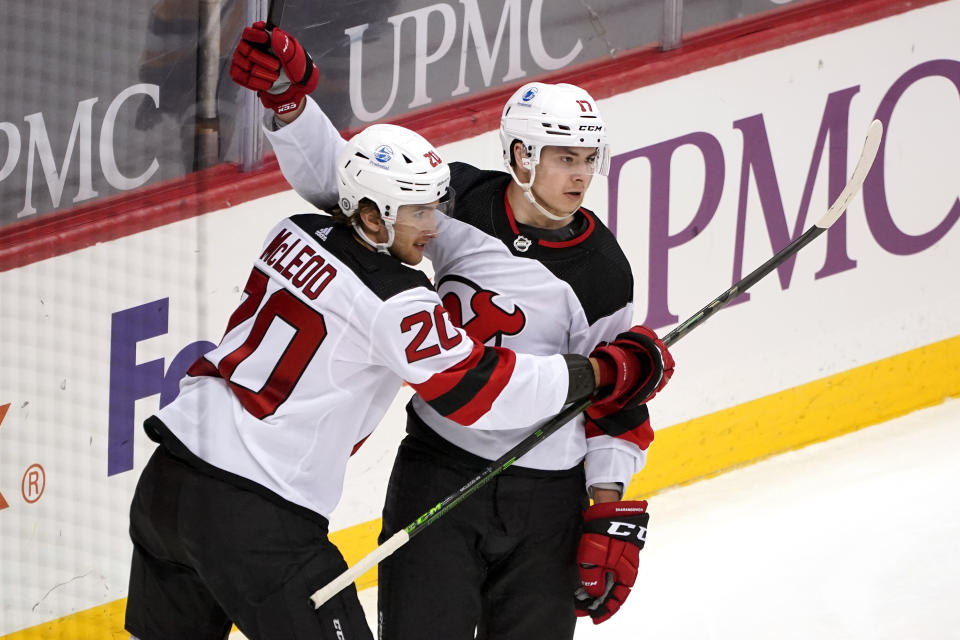 New Jersey Devils' Yegor Sharangovich (17) celebrates his goal with Michael McLeod during the third period of an NHL hockey game against the Pittsburgh Penguins in Pittsburgh, Tuesday, April 20, 2021. (AP Photo/Gene J. Puskar)