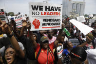 People hold banners as they demonstrate on the street to protest against police brutality in Lagos, Nigeria, Thursday Oct. 15, 2020. Protests against Nigeria's police continued to rock the country for the eighth straight day Thursday as demonstrators marched through the streets of major cities, blocking traffic and disrupting business. (AP Photo/Sunday Alamba)