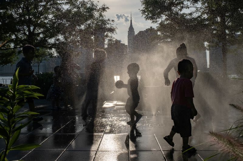 Children cool off in a fountain while enjoying a warm and humid day at Gantry Plaza State Park following the outbreak of the coronavirus disease (COVID-19), in Long Island City, New York