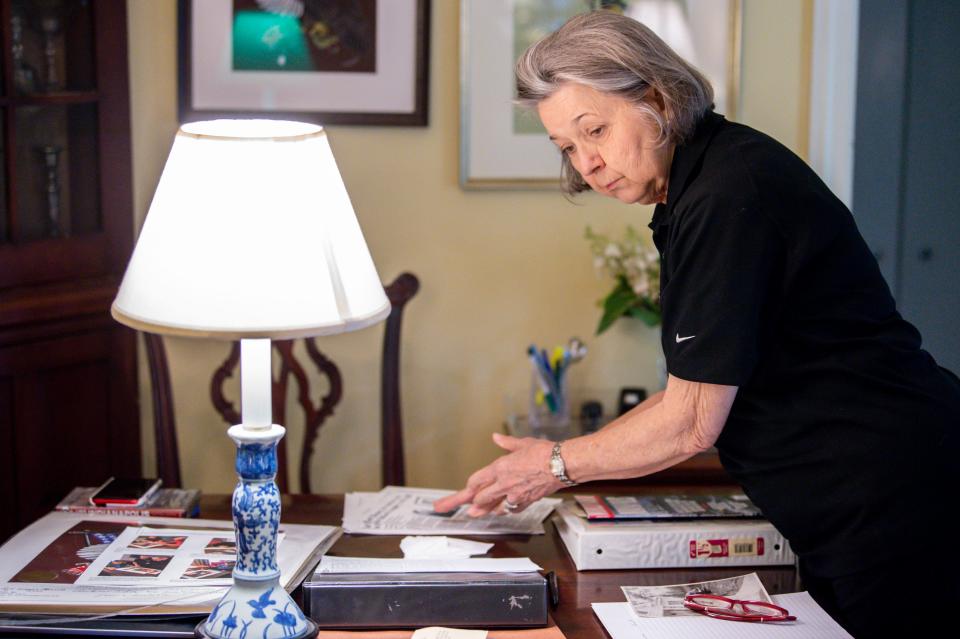 Marilyn Henry looks over the memorabilia and records about the U.S.S. Indianapolis spread out over her dining room table at her home in Belle Meade, Tenn., on Monday, July 19, 2021.