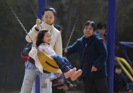 A mother pushes her daughter on a swing in Beijing, April 3, 2013. REUTERS/Jason Lee/Files
