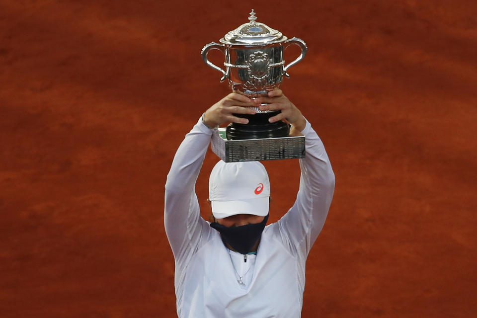 Poland's Iga Swiatek holds the trophy after winning the final match of the French Open tennis tournament against Sofia Kenin of the U.S. in two sets 6-4, 6-1, at the Roland Garros stadium in Paris, France, Saturday, Oct. 10, 2020. (AP Photo/Alessandra Tarantino)