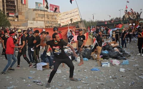 An Iraqi demonstrator uses a slingshot to hurl rocks - Credit: AFP