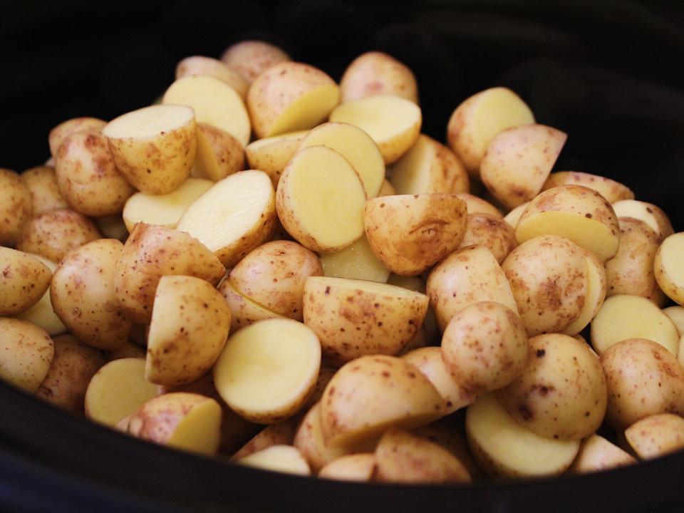 chopped potatoes in a black slow cooker