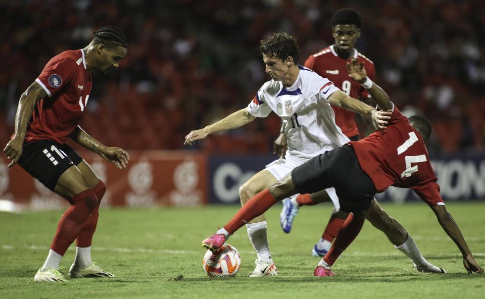 United States' Brenden Aaronson, center, fights for the ball with Trinidad and Tobago's Shannon Gomez, right, and Real Gill, left, during a CONCACAF Nations League quarterfinal soccer match in Port of Spain, Trinidad and Tobago, Monday, Nov. 20, 2023. (AP Photo/Azlan Mohammed)