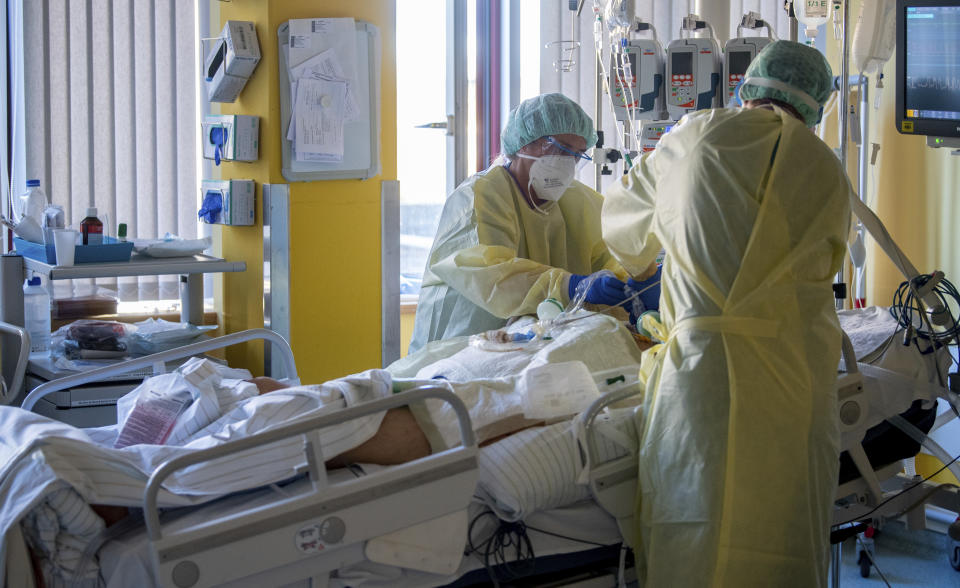 Intensive care nurses treat a patient severely ill with Covid-19 in the Corona intensive care unit at the University Hospital in Halle/Saale on Monday, Nov. 22, 2021. The German air force Luftwaffe will begin assisting the transfer of intensive care patients from hospitals in Bavaria to northern German states.(Hendrik Schmidt/dpa via AP)