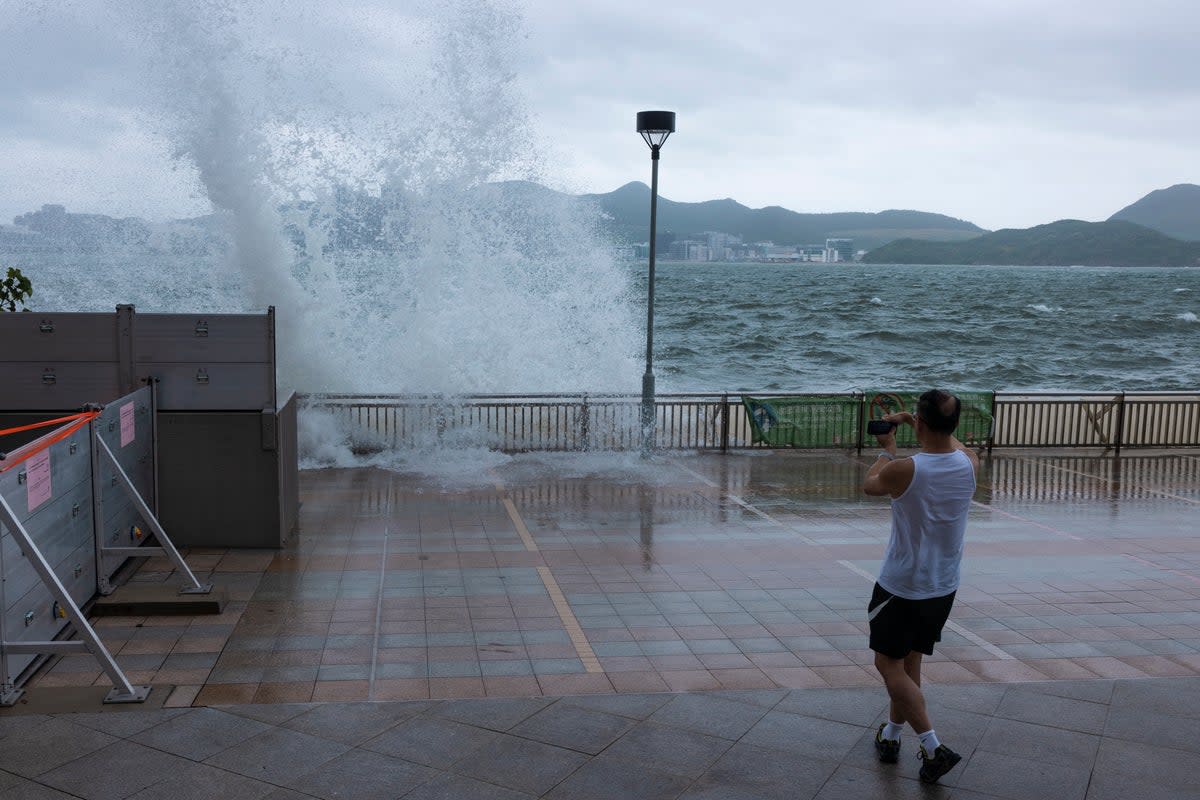 A man looks at the waves on a promenade during a typhoon in Hong Kong (AP)