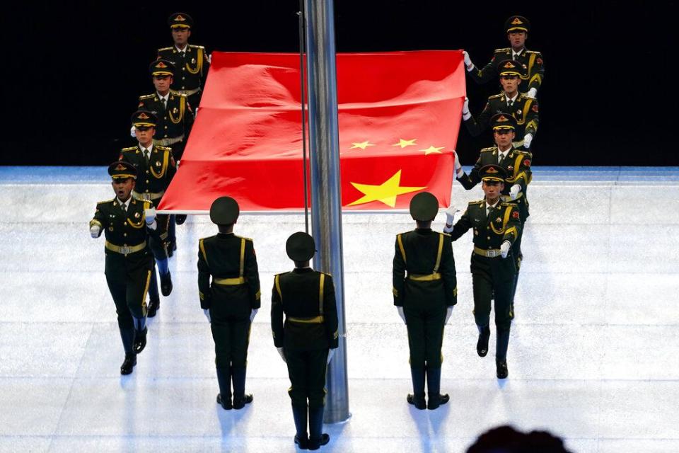 The Chinese national flag is carried to the stage to be raised during the opening ceremony of the 2022 Winter Olympics, Friday, Feb. 4, 2022, in Beijing. (AP Photo/Matt Slocum)