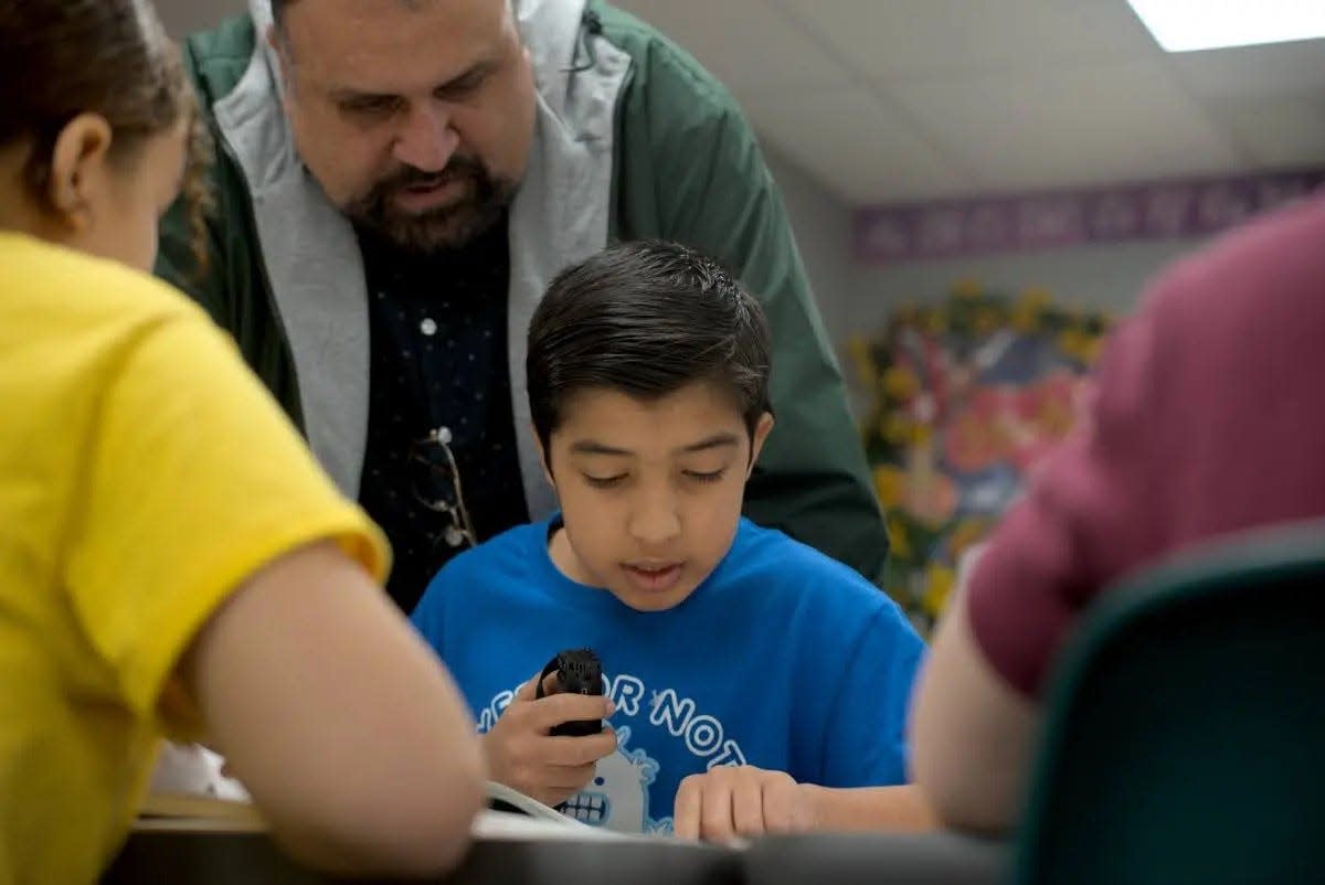 Mia Qadri, an Afghan refugee liaison hired by Tulsa Public Schools, stands ready to help fifth grade Afghan student Mohammed “Garis” Fáizy as he reads out loud to his classmates.