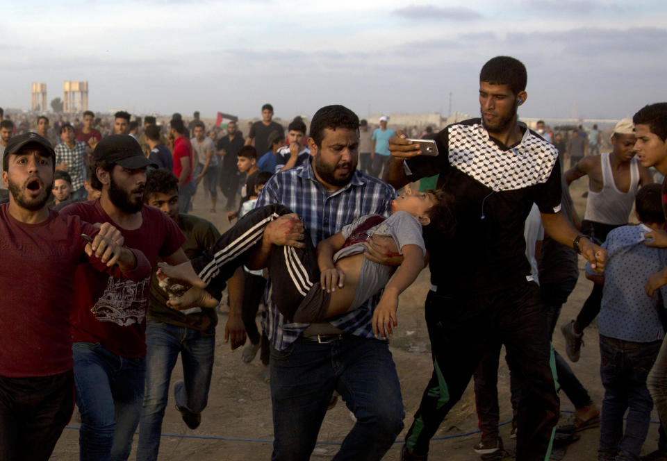 Palestinians carry 12 year-old boy, Fares Sersawi, who died later from his wound after being shot by Israeli troops during a protest at the Gaza Strip's border with Israel, Friday, Oct. 5, 2018. (AP Photo/Khalil Hamra)