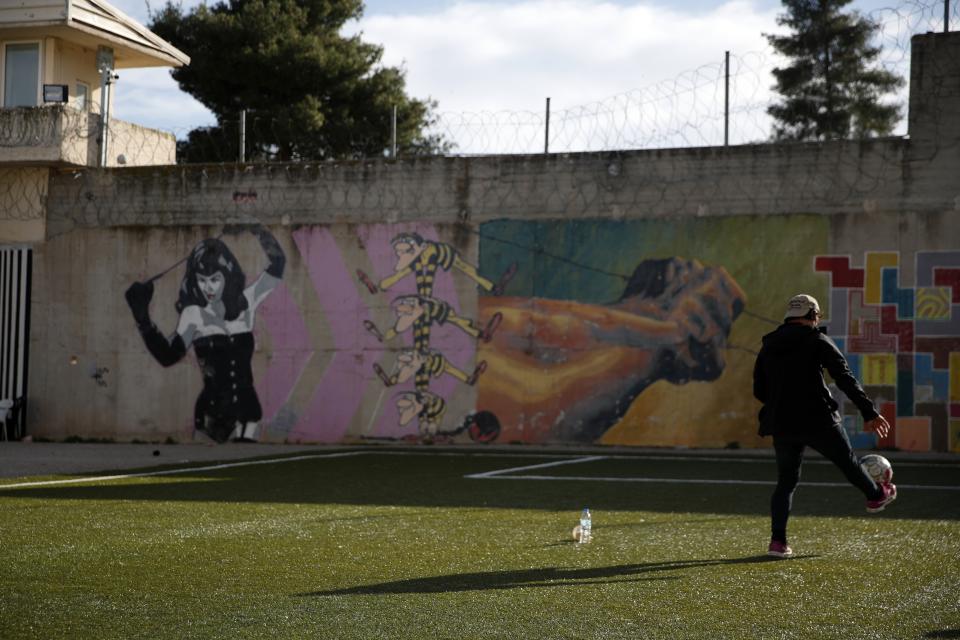 An inmate plays with a ball at the yard of Avlona prison, north of Athens, Wednesday, Feb. 10, 2021. With Greece's schools shut due to the pandemic, all lessons have gone online. But the online world isn't within reach of everyone _ and particularly not within reach of the students of Avlona Special Youth Detention Center, where internet devices are banned by law from the cells. (AP Photo/Thanassis Stavrakis)