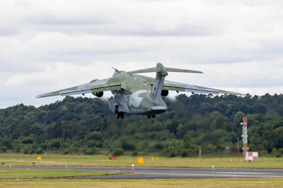 The C-390 Millennium takes off from a runway during an airshow ceremony.