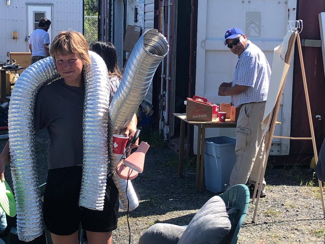 Shannon Jennings at the ReStore with some of her finds: ducting and a desk lamp. The seasonal store, run by Habitat For Humanity Northwest Territories, is set to close because the organization says it is hard to find staff. (Submitted by Spencer Tracy - image credit)