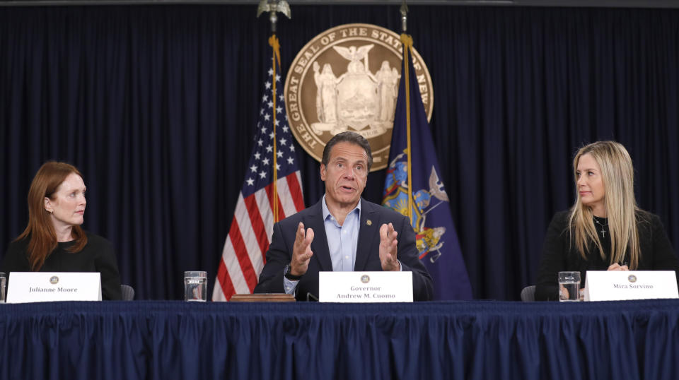 Actresses Mira Sorvino, right, and Julianne Moore look on as New York Gov. Andrew Cuomo speaks before signing a bill that increases the statute of limitations in rape cases during a bill signing ceremony in New York, Wednesday, Sept. 18, 2019. The actresses were there as supporters of the bill and as members of the Time's Up movement, which advocates for women's rights. (AP Photo/Seth Wenig)