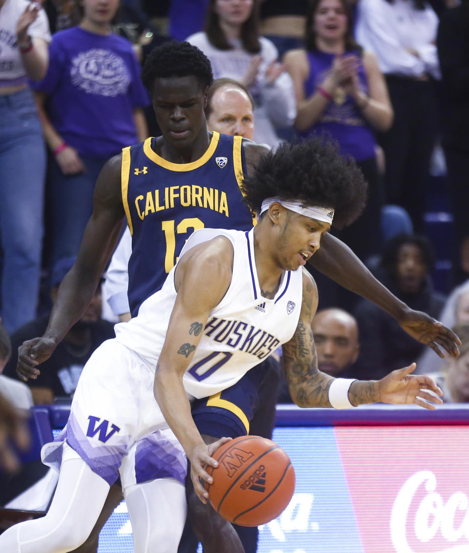 Washington guard Koren Johnson (0) drives around California forward Kuany Kuany after getting possession of the ball during the first half of an NCAA college basketball game Saturday, Jan. 14, 2023, in Seattle. (AP Photo/Lindsey Wasson)