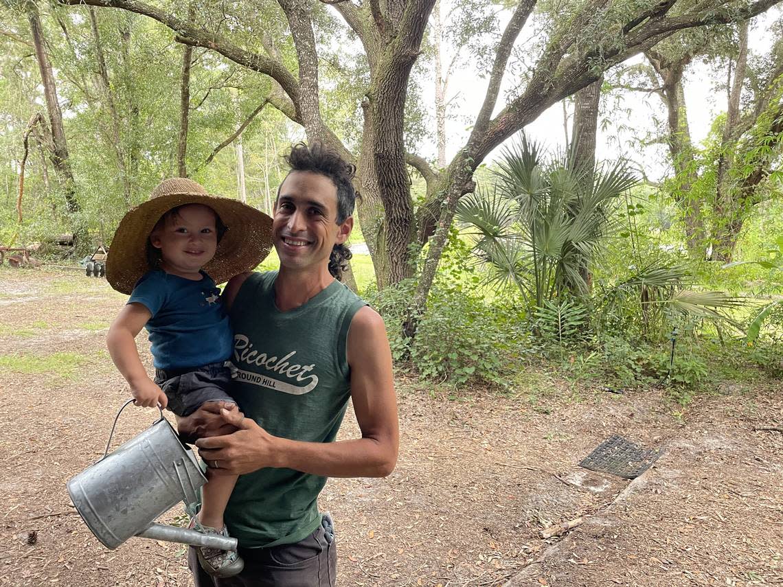After a full day of hurricane preparation on Sept. 27, 2022, farmer Daniel Robleto of Gainesville, Florida, is seen here with his son. Robleto said many farmers across Florida recognize the state’s climate is a gamble. Katie Delk/Fresh Take Florida