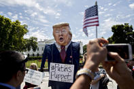 <p>A demonstrator wears an effigy in the likeness of President Trump during a protest at the White House on May 10. (Photo: Andrew Harrer/Bloomberg via Getty Images) </p>